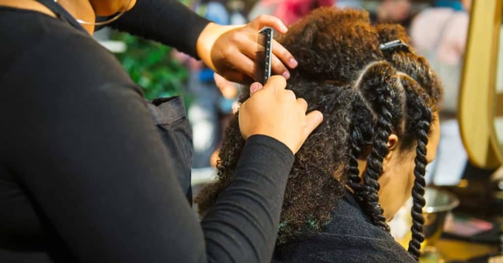 hair dresser braiding a clients hair